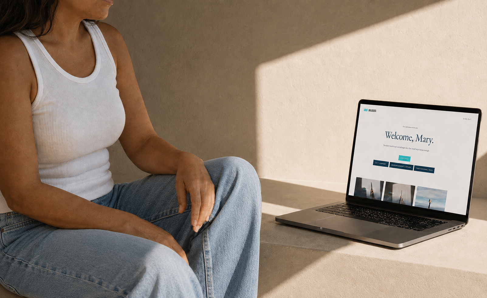 A woman resting in warm light beside a laptop showing the member dashboard