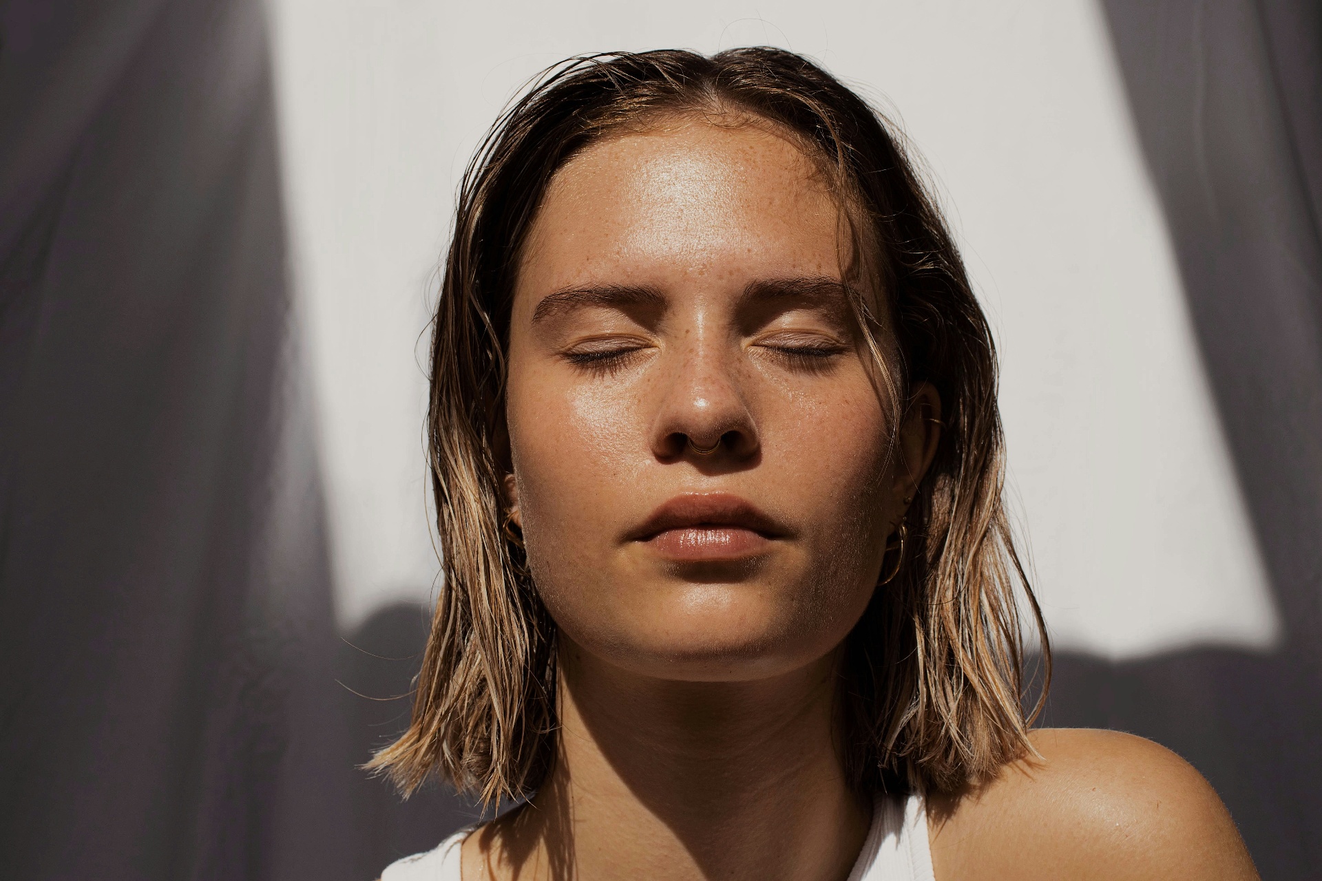A woman with closed eyes resting in warm sunlight