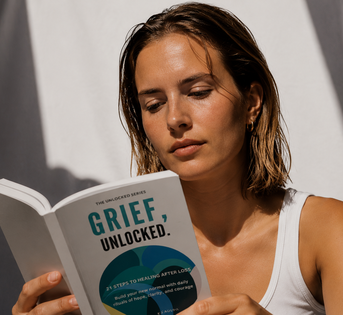 A young woman in soft sunlight reading the Grief, Unlocked book.