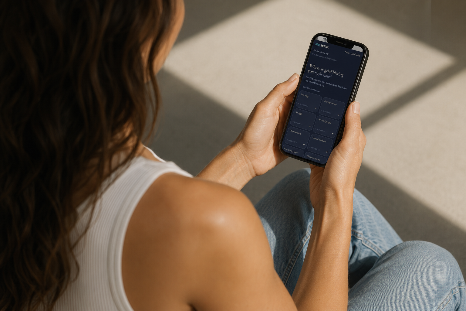 The Pocket Grief Guide open on a phone, showing prompts for different moments of grief
